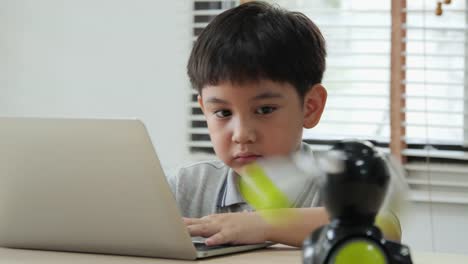 Boy-try-to-test-robots-in-school-science-club.-Project-for-engineering-club-in-school.-People-with-technology-concept.