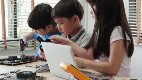 Equipo-de-ingenieros-de-niños-trabajando-juntos,-ensamblando-y-probando-equipos-en-taller.-Personas-con-tecnología-y-concepto-de-innovación.