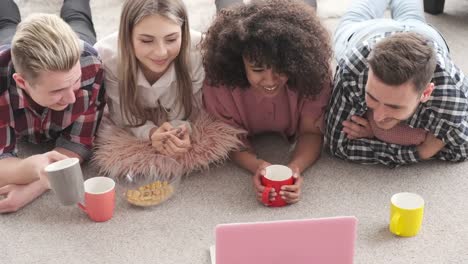 Amigos-bebiendo-café-y-disfrutando-de-la-película-en-el-ordenador-portátil