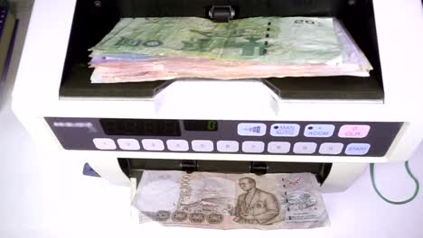 Electronic-money-counter-machine-is-counting-Thai-baht-THB