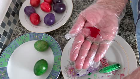 A-woman-in-gloves-paints-eggs