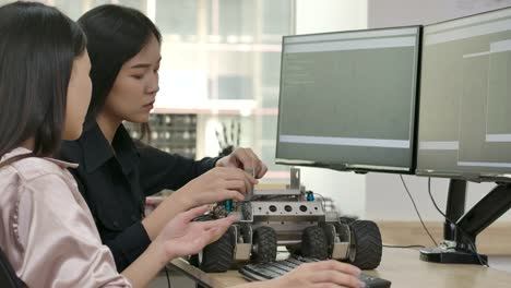 Equipo-de-jóvenes-ingenieros-creativos-de-programación-para-prototipos-de-robótica-en-taller.-Personas-con-concepto-de-tecnología-o-innovación.