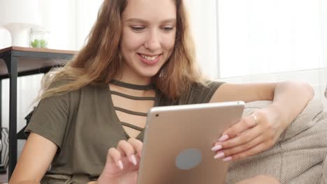 Glücklich-Teenager-Mädchen-mit-digitalen-Tablet-auf-dem-Sofa