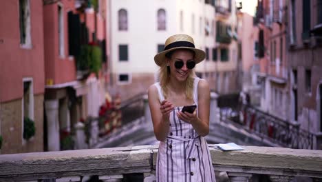 Slow-motion-effect-of-young-cheerful-female-tourist-reading-received-message-from-friend-with-funny-information