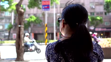 The-Hearing-loss-child-with-sunglasses-is-waiting-for-the-bus-at-the-bus-stop.