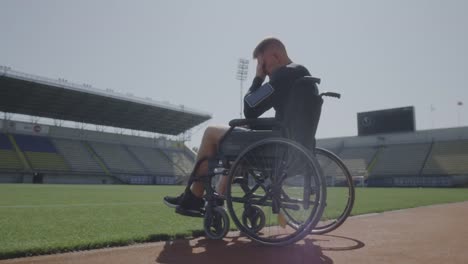 Behindertensportler-sitzt-im-Rollstuhl-auf-einem-Sportplatz