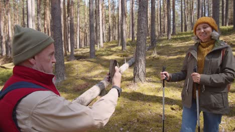 Paar-gealterte-Wanderer-machen-Fotos-während-des-Spaziergangs