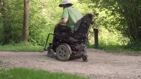 Slow-motion-of-man-in-a-wheelchair-driving-off-road-with-obstacle-on-the-road.-disabled-people-problem-concept