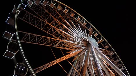 Riesenrad.-Ein-Riesenrad-dreht-sich-vor-dem-Hintergrund-des-Nachthimmels.-Nahaufnahme-eines-Riesenrades-mit-Nachtbeleuchtung.-beleuchtete-Riesenradkonstruktion,-die-sich-vor-dunklem-Nachthimmel-Hintergrund-dreht.