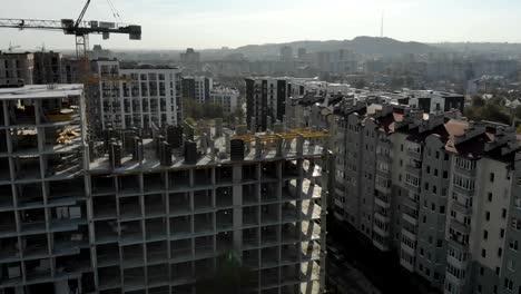 Flug-in-der-Nähe-des-unvollendeten-monolithischen-Hauses.-Baukran-in-der-Nähe-der-Baustelle.-Top-Ansicht-der-Konstruktion