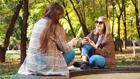 Chicas-de-moda-surfeando-redes-sociales-en-el-parque