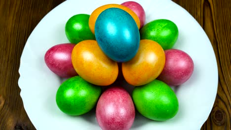 Hand-puts-on-a-plate-the-Easter-decorated-and-painted-colored-egg-during-a-Resurrection-Sunday-or-Pascha