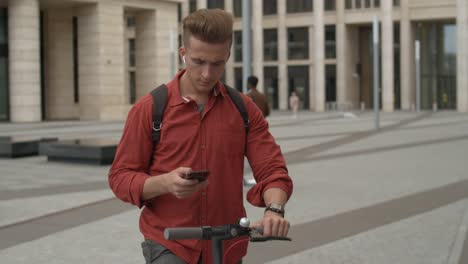 Hipster-Mann-mit-E-Scooter-und-Handy