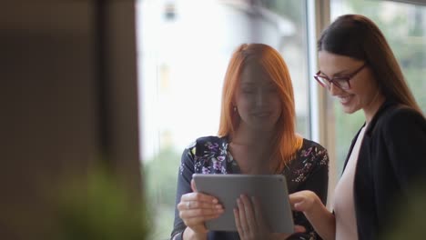 Junge-Frauen-arbeiten-mit-einem-digitalen-Tablet-im-Büro