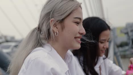 Asian-lesbian-couples-playing-soap-bubbles-while-standing-on-the-bridge.