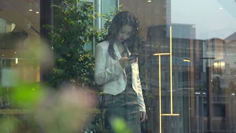 Business-Woman-Asian-Businesswoman-With-Smartphone-In-Office-Building