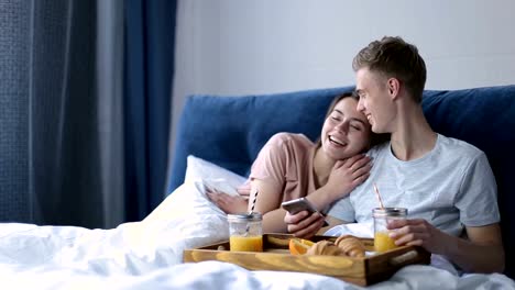 Pareja-alegre,-disfrutar-de-un-desayuno-romántico-en-la-cama