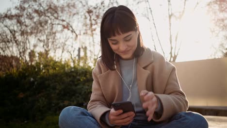 Mujer-bonita-utiliza-el-smartphone-en-el-Parque