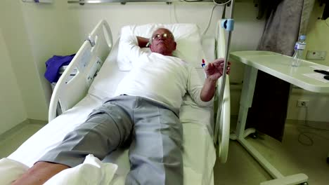 Elderly-70-plus-year-old-man-recovering-from-surgery-in-a-hospital-bed