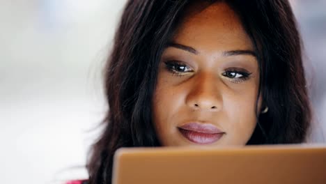 Woman-using-tablet-pc-computer-against-light-window-background