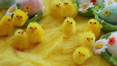 Baby-yellow-Easter-toys-chicks-and-eggs-on-a-background-of-feathers.-Festive-video-greeting-card