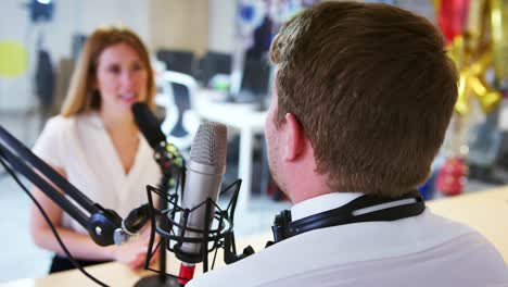 Young-man-interviewing-a-guest-in-a-studio-for-a-podcast