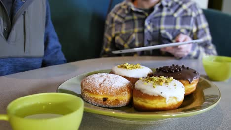 Especie-de-Donut-desayuno-negocios-reunión-repostero-desplazamiento-pantalla-Tablet