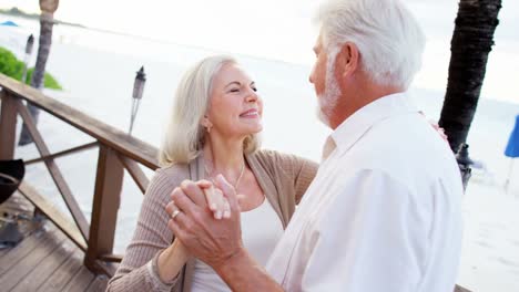 Loving-retired-Caucasian-couple-dancing-at-vacation-resort