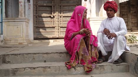 Indische-Paare-vor-alten-Rajasthani-Architektur-sitzen-und-plaudern