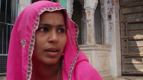 Pan-close-up-from-a-handsome-man-with-red-turban-to-a-pretty-lady-in-pink-sari-in-Rajasthan,-India