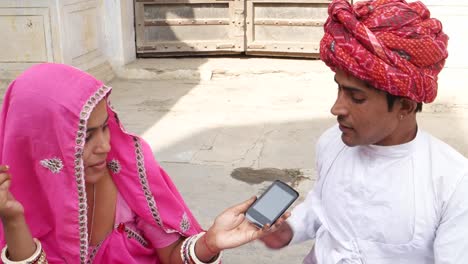 Tilt-down-to-a-Rajasthani-couple-sharing-a-cell-phone-and-looking-at-the-camera-architecture