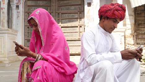 Young-man-and-woman-busy-and-irgnoring-each-other-while-happy-and-joy-on-their-cell-phone-mobile-ignoring-architecture