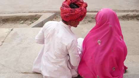 Pareja-de-ropas-tradicionales-en-Pushkar,-Rajasthan,-India-compartir-cuidado-amor-teléfono-celular-móvil