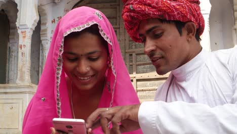 Couple-laughing-smiling-and-sharing-something-joy-happiness-on-touch-screen-mobile-phone