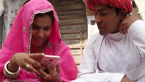 Tilt-up-to-Rajasthani-couple-in-traditional-dress-in-from-of-traditional-house-text-message-notification