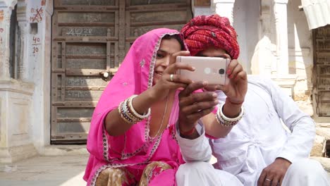 Inclinación-hacia-una-pareja-tradicional-tomando-selfie-cámara-en-fotografía-móvil-en-Rajasthan-India