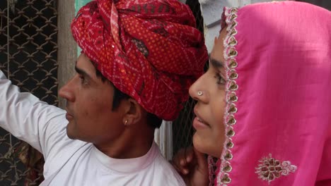 Close-up-to-Couple-taking-camera-selfie-on-mobile-phone-photography-in-front-of-their-house-with-traditional-architecture