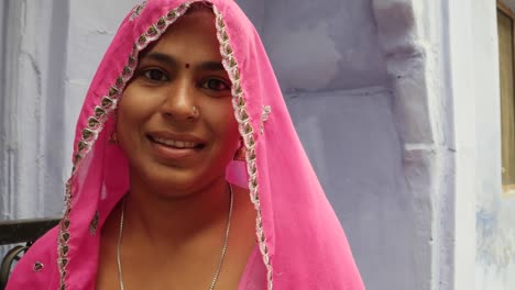 Close-up-good-looking-pretty-woman-happy-smiling-joy-and-wearing-a-pink-traditional-Indian-dress,-talking-to-the-camera