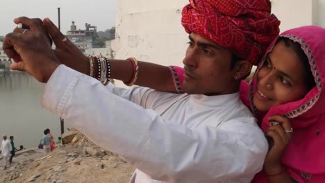 India-pareja-teniendo-hermosa-puesta-de-sol-cámara-teléfono-fotos-lago-de-Pushkar,-Rajastán