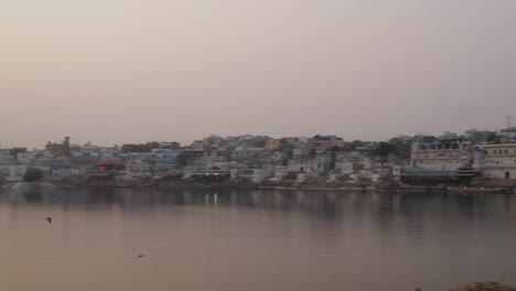 Pan-vom-indischen-Ehepaar-in-Tracht,-die-Fotos-von-Sonnenuntergang-am-Heiligen-Pushkar-See,-Rajasthan