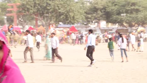 Schwenken-Sie-auf-schönen-indischen-Paar-in-der-traditionellen-Kleidung-an-der-belebten-Fairgrounds-Pushkar-Fair,-Indien
