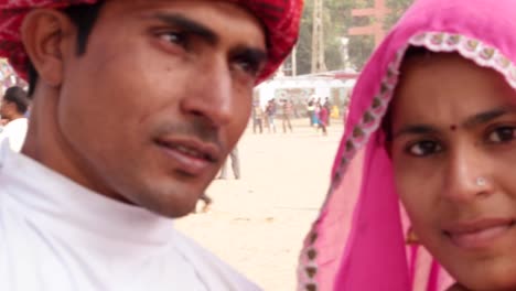 Pan-close-up-of--attractive-Indian-couple-at-the-crowded-fairgrounds-of-Pushkar-Fair,-Rajasthan,--India