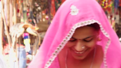 Wife-in-pink-sari-blows-bubbles-while-her-husband-in-black-sunglasses-and-red-turban-watches