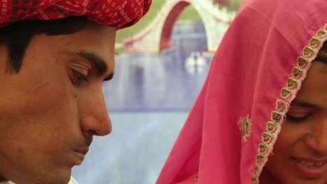 Closeup-of-Indian-couple-having-a-discussion-sitting-with-a-colourful-background