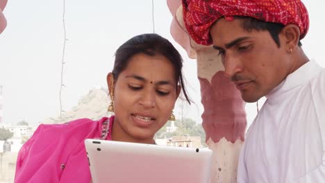 Aprendizaje-de-trabajo-Rajasthani-par-enseñar-a-compartir-en-una-tableta-vestida-con-sari-rosa-y-turbante-rojo-en-la-India