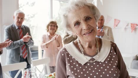 Ältere-Dame-posiert-auf-Geburtstag-Abendessen-mit-Freunden