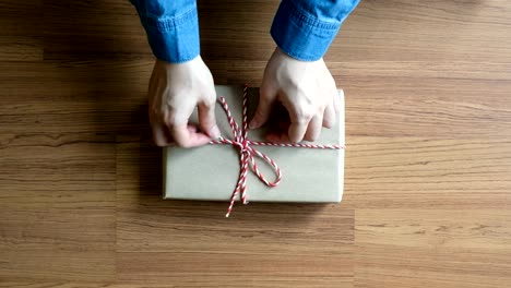 Frau-Verpackung-Weihnachten-präsentiert-auf-hölzernen-Schreibtisch-Händen-von-oben,-Ansicht-von-oben