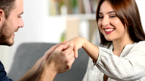 Man-putting-engagement-ring-to-his-girlfriend