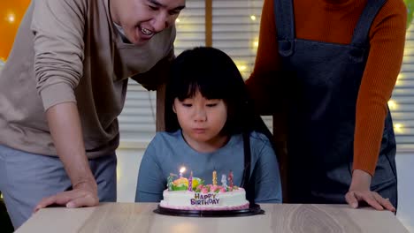 Cute-girl-blows-out-candles-on-birthday-cake-at-party-with-happy-emotion.-People-with-party-and-celebration-concept.-4K-Resolution.