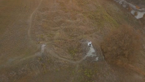 Joven-y-hermosa-pareja-junto-en-la-montaña.-Hermoso-novio-y-novia.-Disparos-desde-el-aire.-Toma-aérea